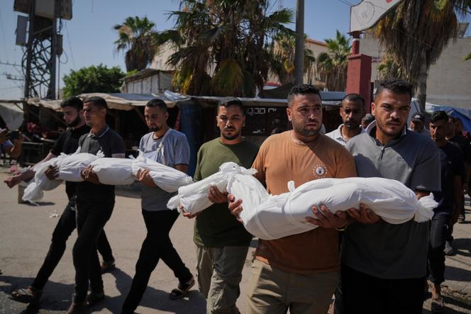 Os parentes carregam os corpos de duas irmãs, Mira e Sabah Bashir (8 e 10 anos) mortos por um bombardeio do exército israelense em Deir al-Balah, na faixa de Gaza, em 2 de julho de 2025. 