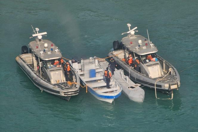 Dois barcos na marinha colombiana moldam um semi-submersível não tripulado, conhecido como embarcação de baixo perfil, na Côte du Parc Tayrona, perto de Santa Marta, Colômbia, 2 de julho de 2025. 