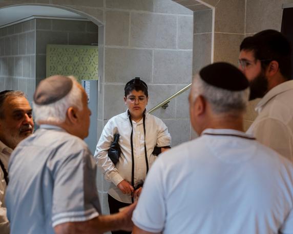Armand Azoulay, Alain Benhamou, Sidney Haddad, Avraham Lahmi (from left to right), and Lahmi's son gather to decide if they have enough people present to start a prayer service, given the limited number of participants. Bondy Synagogue, June 29, 2025.