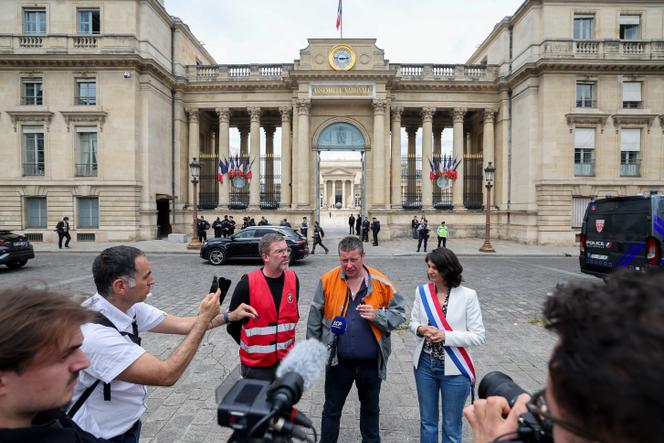 Gaëtan Lecocq (au centre), secrétaire général de la CGT ArcelorMittal Dunkerque (Nord), et Aurélie Trouvé (à droite), députée (LFI) de Seine-Saint-Denis, qui porte la proposition de loi de nationalisation d’ArcelorMittal, devant l’Assemblée nationale, à Paris, le 13 mai 2025.