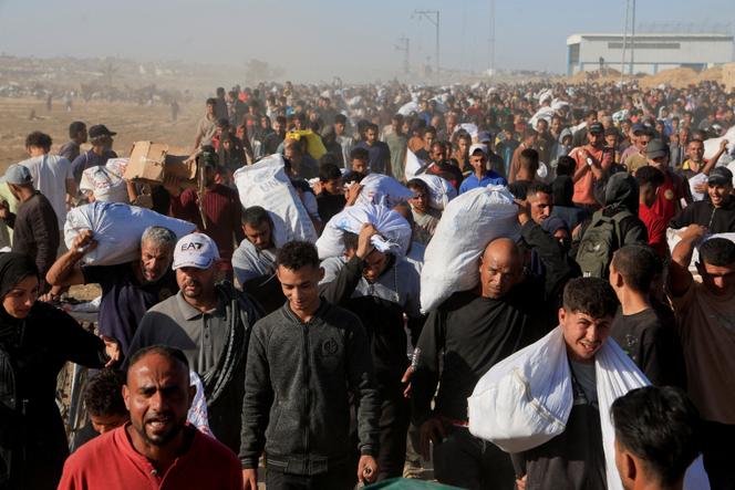 Des Palestiniens transportent des fournitures d’aide de la Gaza Humanitarian Foundation, à Khan Younès, dans le sud de la bande de Gaza, le 29 mai 2025.