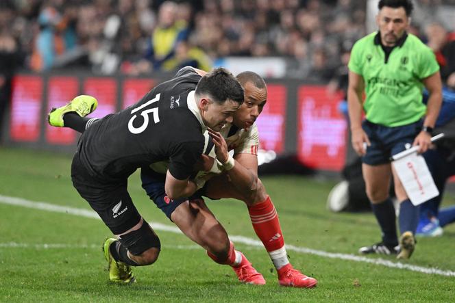 France's Gael Fickou (C) is tackled by New Zealand's Will Jordan during the first international rugby Test match between New Zealand and France at Forsyth Barr Stadium in Dunedin on July 5, 2025.