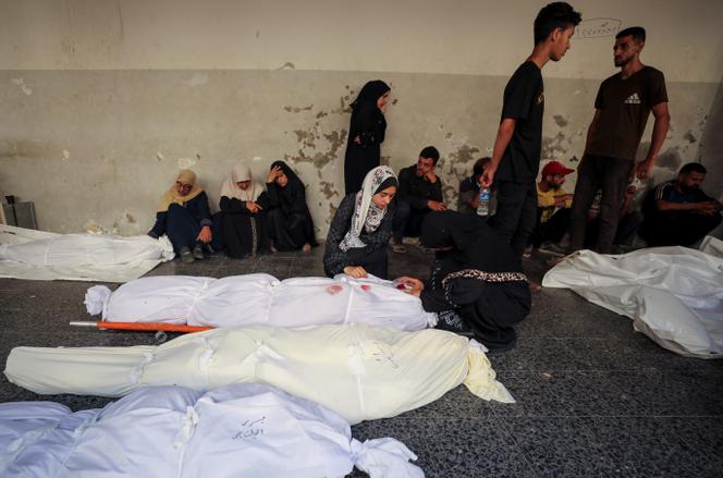 Des proches en deuil se rassemblent près des corps des personnes tuées par un bombardement israélien sur une école abritant des déplacés, à l’hôpital Al-Ahli, dans la ville de Gaza, le 5 juillet 2025. 