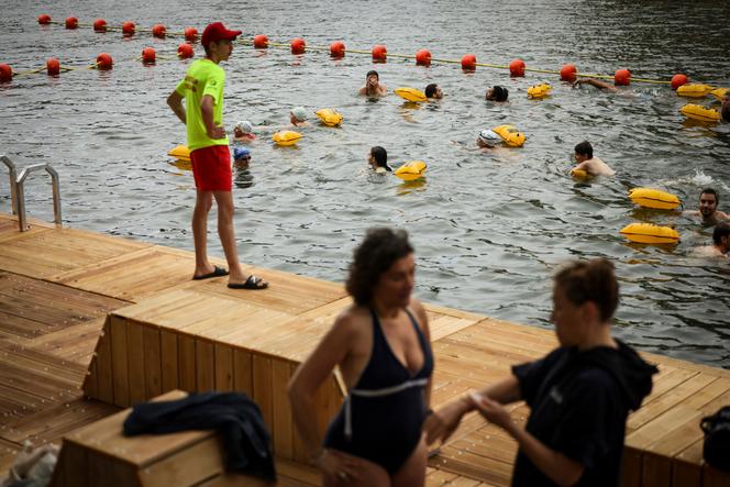 People swim at the Bras Marie safe bathing site on the Seine river in Paris, France, Saturday, July 5, 2025, during the opening of the three Seine swimming pools, as part of the 'Paris Plages' event. 