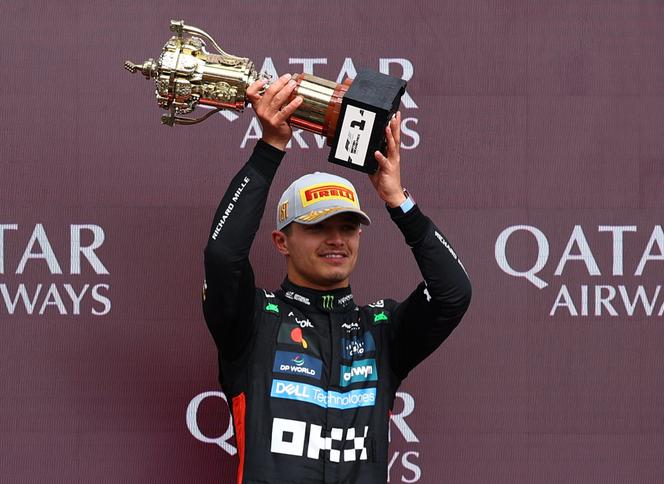 McLaren's Lando Norris celebrates with a trophy on the podium after winning the British Grand Prix, Silverstone Circuit, Silverstone, UK, July 6, 2025.