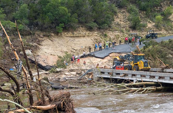 As equipes trabalham para limpar os detritos da ponte de loop de cadeiras ao longo do rio Guadalupe no sábado, 5 de julho de 2025, em Ingram, Texas.