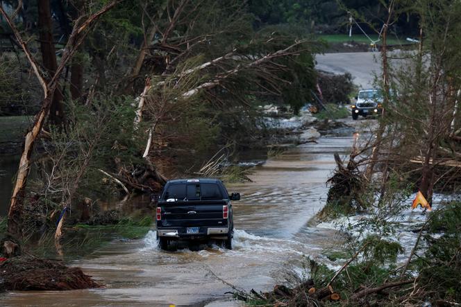 Um veículo enruga por uma estrada inundada, após inundações repentinas, em Hunt, Texas, EUA, 6 de julho de 2025. 