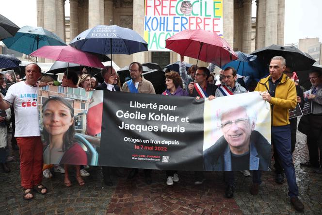 Des proches et des sympathisants posent derrière une banderole avec le portrait de Cécile Kohler et Jacques Paris, détenus en Iran depuis mai 2022, lors d’un rassemblement place du Panthéon, à Paris, le 6 juillet 2025.