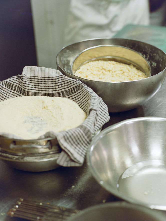 Deux étapes du couscous: dans le tamis, couscous aéré et humidifié; dans la serviette, couscous humidifié, aéré et tamisé.