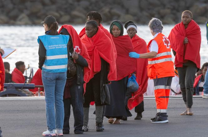 Un agent de Frontex, en dossard bleu, à l’arrivée de migrants sauvés de la noyade par une unité espagnole de sauvetage en mer, dans le port d’Arrecife (Espagne), le 3 janvier 2025.