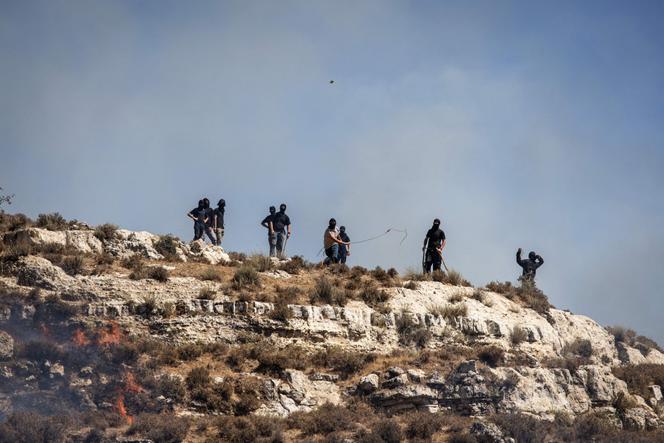 Des colons israéliens lancent des pierres sur des Palestiniens depuis le sommet d’une colline dans le village de Sinjil, en Cisjordanie occupée, le 4 juillet 2025.