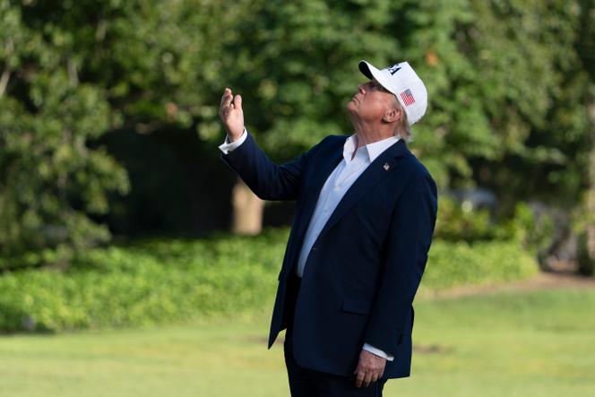 Le président américain, Donald Trump, regarde le drapeau américain sur le mât de la pelouse sud alors qu’il arrive à la Maison Blanche, dimanche 6 juillet 2025, à Washington.