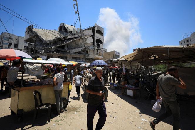 Des Palestiniens marchent après des frappes israéliennes sur des bâtiments du marché de la vieille ville de Gaza, dans la ville de Gaza, le 9 juillet 2025.