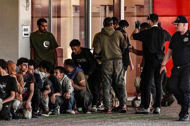 Des migrants sont rassemblés par des gardes-côtes grecs après avoir débarqué d’un cargo, dans le port de Lavrio, au sud d’Athènes, le 10 juillet 2025.
