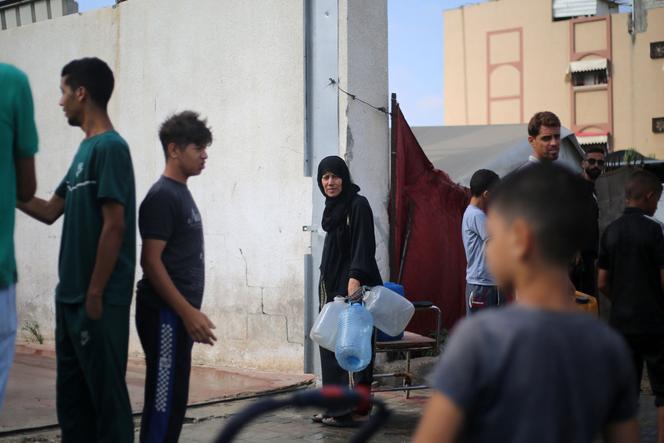 Des Palestiniens déplacés vont chercher de l’eau à un point de distribution dans le camp de réfugiés de Nousseirat, dans le centre de la bande de Gaza, le 10 juillet 2025.