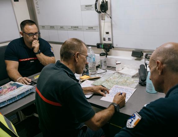 Des sapeurs-pompiers de Narbonne préparent des éléments pour une communication imminente, au sein de leur poste de commandement établi dans les environs de Bages (Aude), le 9 juillet 2025.