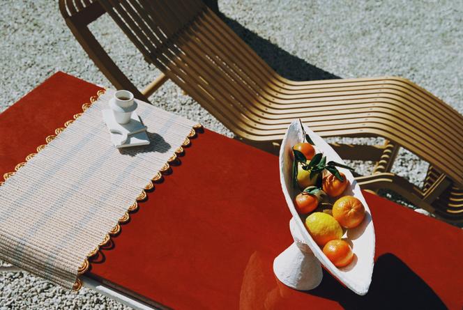 Cadeira de Tokyo Lounge de Charlotte Perriand reeditada por Cassina, mesa de café Picasta e prato, Laura Navarro Set, xícara e sob copo Léa Ginac, na casa de Isabelle Castanier, em Saint-Tropez.