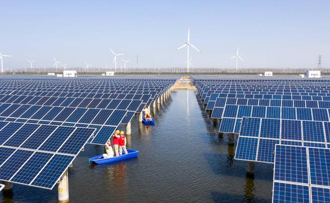 Des ouvriers inspectent les panneaux solaires d’une centrale photovoltaïque en construction à Binhai, ville nouvelle de la périphérie de Tianjin, au nord-est de la Chine, le 15 mars 2022.