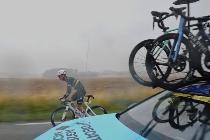 Le coureur slovène Tadej Pogacar (UAE Team Emirates-XRG), grand favori de la course, roule sous la pluie à côté de la voiture d’assistance de l’équipe Decathlon-AG2R La Mondiale, lors de la deuxième étape entre Lauwin-Planque (Nord) et Boulogne-sur-Mer (Pas-de-Calais), le 6 juillet 2025.