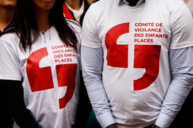 Des manifestants portant des tee-shirts avec l’inscription « Comité de vigilance des enfants placés » participent à un rassemblement en hommage aux enfants placés qui se sont donnés la mort, sur la place Jacques-Bainville près de l’Assemblée nationale, à Paris, le 7 mai 2024.
