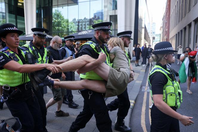 Os policiais carregam um manifestante detido, durante um protesto pedindo o de-prostecrito do grupo de ação da Palestina, em Manchester, Inglaterra, em 12 de julho de 2025.  
