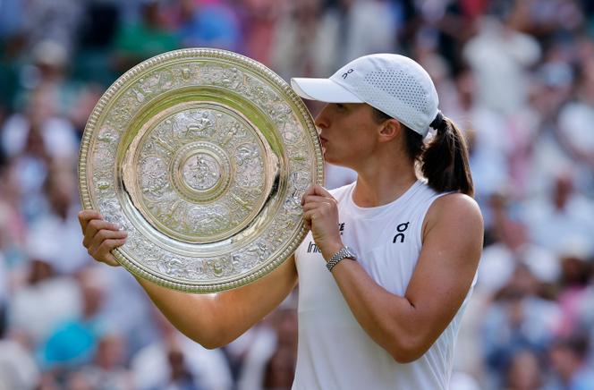 Après sa victoire face à l’Américaine Amanda Anisimova, la Polonaise Iga Swiatek soulève le Venus Rosewater Dish, le trophée du simple dames à Wimbledon, le samedi 12 juillet 2025. 