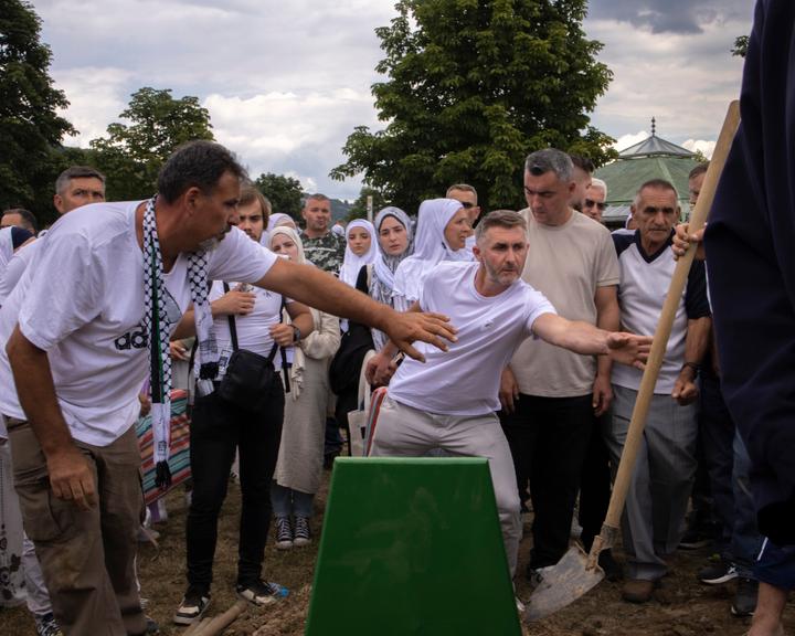 Zelda Avdic et ses proches devant la sépulture de son petit frère Senajid Avdic, 16 ans, le jour des commémorations du génocide à Srebrenica, en Bosnie-Herzégovine, le 11 juillet 2025.