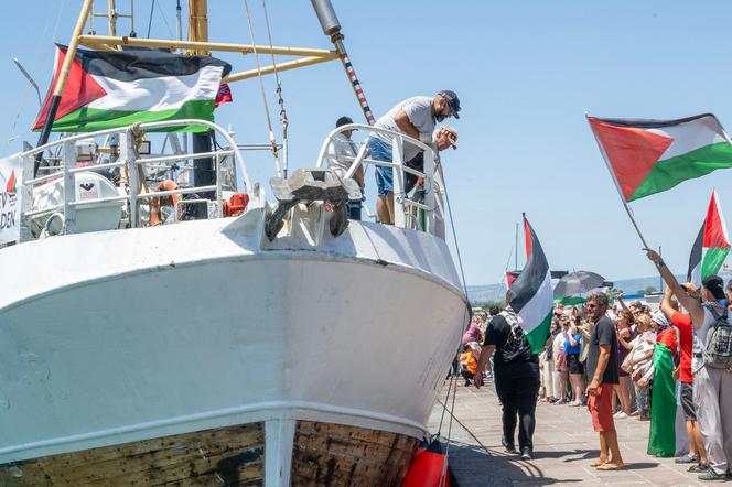 Des manifestants arborant des drapeaux palestiniens se rassemblent près du navire « Handala » de la Flottille pour la liberté, dans le port de Syracuse, en Sicile, le 13 juillet 2025.