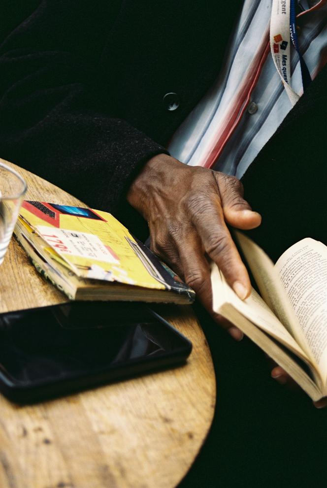Sur la table, le livre « Les jeunes s’interrogent, réponses pratiques, volume 1 », que Daouda Diakhite a trouvé en Espagne, qu’il a lu lors du trajet le menant en France et qu’il protège d’une couverture bricolée à partir d’une publicité.