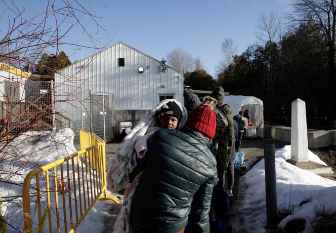 Des migrants haïtiens en provenance des Etats-Unis entrent au Canada, par le poste frontière non-officiel de Roxham Road, le 24 mars 2023.