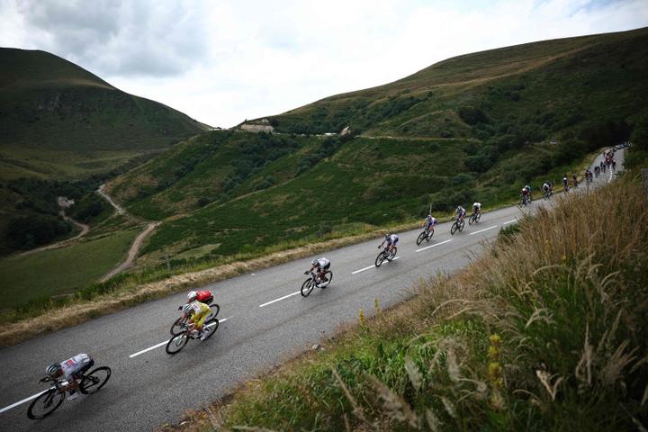 Le peloton étiré dans la descente du col de la Croix-Morand (Puy-de-Dôme), lors de la dixième étape du Tour de France, le 14 juillet 2025.