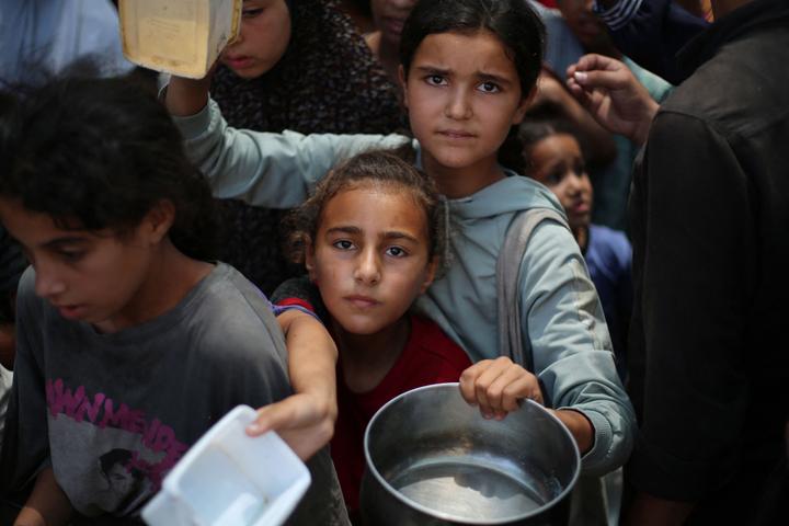 Des fillettes palestiniennes font la queue pour obtenir de la nourriture auprès d’une cuisine caritative, dans le camp de Nousseirat, dans le centre de la bande de Gaza, le 15 juillet 2025.