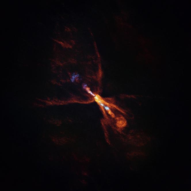 Vue de l’étoile HOPS-315, potentiel futur centre d’un système planétaire, réalisée par le radiotélescope ALMA, au Chili. En orange et en bleu, des jets de gaz sont émis par l’étoile, autour de laquelle un disque de poussières et de gaz sera le siège de futures planètes.