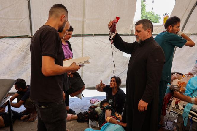 Le père Carlos, de l’église de la Sainte-Famille, à Gaza, aide les blessés après la frappe israélienne, le 17 juillet 2025.