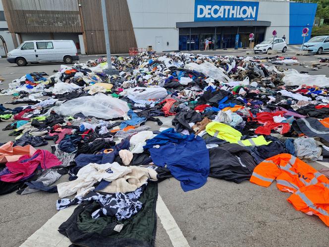 Des déchets textiles déversés sur le parking d’un Decathlon, à l’initiative de Relais, qui collecte, trie et valorise les vêtements usagés, à Houdemont (Meurthe-et-Moselle), le 15 juillet 2025.