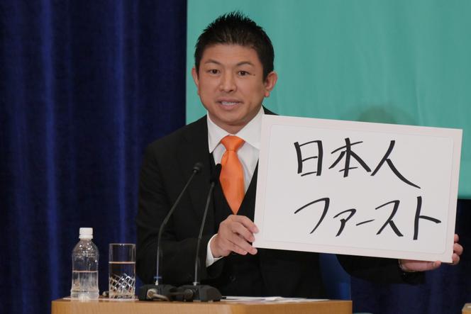 Sohei Kamiya, à la tête du parti Sanseito, brandit une pancarte avec le slogan « Japonais d’abord », lors d’un débat avec les représentants des autres partis politiques du pays, à Tokyo, le 2 juillet 2025. 