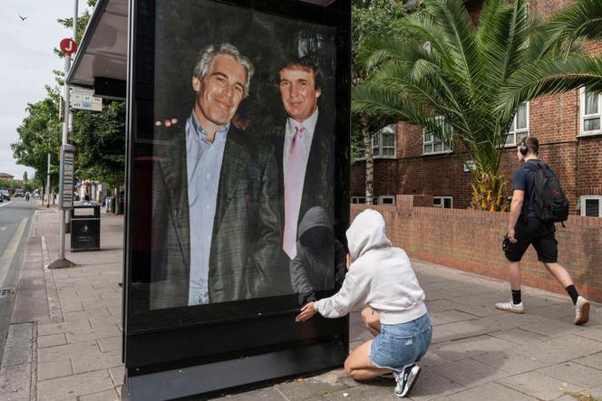 Une militante met sur un abribus une affiche de Jeffrey Epstein aux côtés de Donald Trump, près de l’ambassade américaine à Londres, le 17 juillet 2025.
