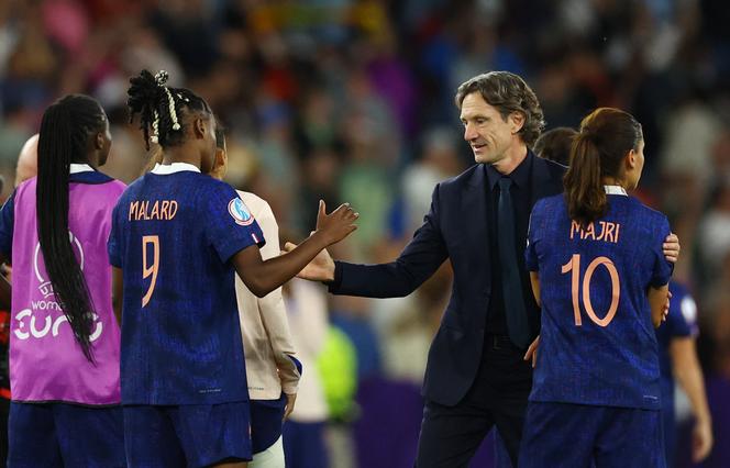 Melvine Malard tape dans la main du sélectionneur de l’équipe de France de football, Laurent Bonadei, après la défaite des Bleues aux tirs au but, en quarts de finale de l’Euro 2025 face à l’Allemagne, à Bâle (Suisse), le 19 juillet 2025