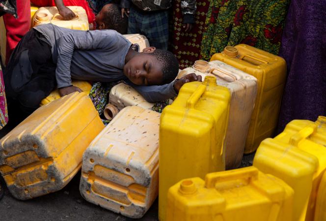 Un enfant dort en attendant de remplir des bidons d’eau, à Goma, dans la province du Nord-Kivu, en République démocratique du Congo, où les coupes dans les programmes de l’Usaid ont créé des pénuries d’eau, le 16 juin 2024.