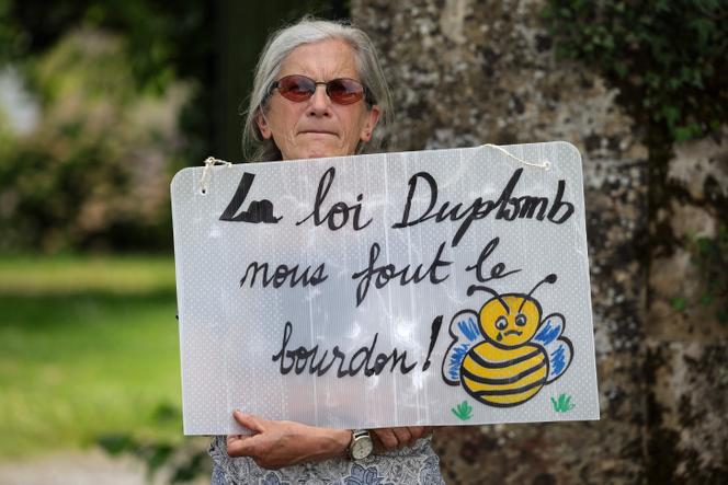  Une militante de la Confédération paysanne tient une pancarte sur laquelle on peut lire « La loi Duplomb nous fout le bourdon ! », lors de la visite de la ministre de l’agriculture et de la souveraineté alimentaire, Annie Genevard, dans une ferme à Saint-Michel (Gers), le 5 juin 2025.