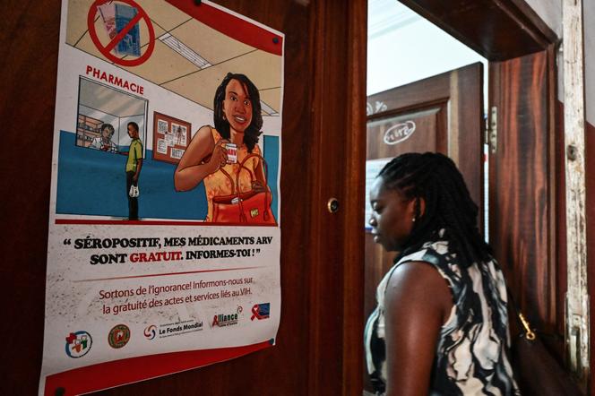 Une femme passe devant une affiche sur la lutte contre le VIH lors d’une conférence de presse sur les effets des coupes de l’Usaid, à Abidjan, le 4 mars 2025.