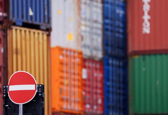 Des conteneurs empilés derrière un panneau « Entrée interdite », dans le port de Duisburg, en Allemagne, le 14 juillet 2025.