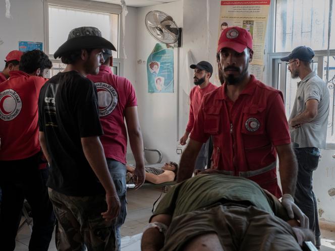 Des membres du Croissant-Rouge syrien transportent un combattant tribal blessé sur le front de Souweïda dans un centre de santé primaire dans la ville voisine de Bousra Al-Harir, en Syrie, le 19 juillet 2025.