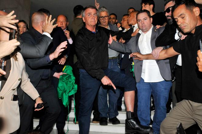 L’ancien président brésilien Jair Bolsonaro montre le bracelet électronique que la Cour suprême lui a ordonné de porter, au Congrès, à Brasilia, le 21 juillet 2025. 