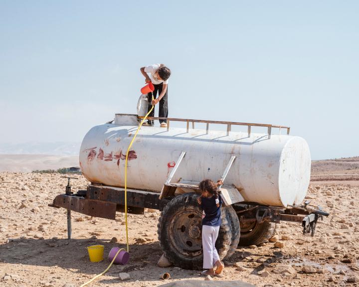 Une fille de la famille Mleihat puise de l’eau à la citerne qui est l’unique point d’eau de Balqa, le 20 juillet 2025. Les Palestiniens ne peuvent plus utiliser les sources du village, qui ont été confisquées par les colons et doivent acheter de l’eau à une entreprise privée.