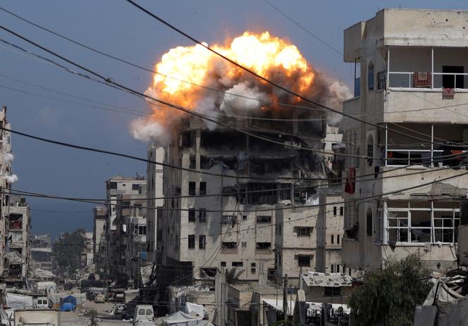 De la fumée et des flammes s’élèvent d’un bâtiment résidentiel bombardé par l’armée israélienne, à Gaza, le 21 juillet 2025.