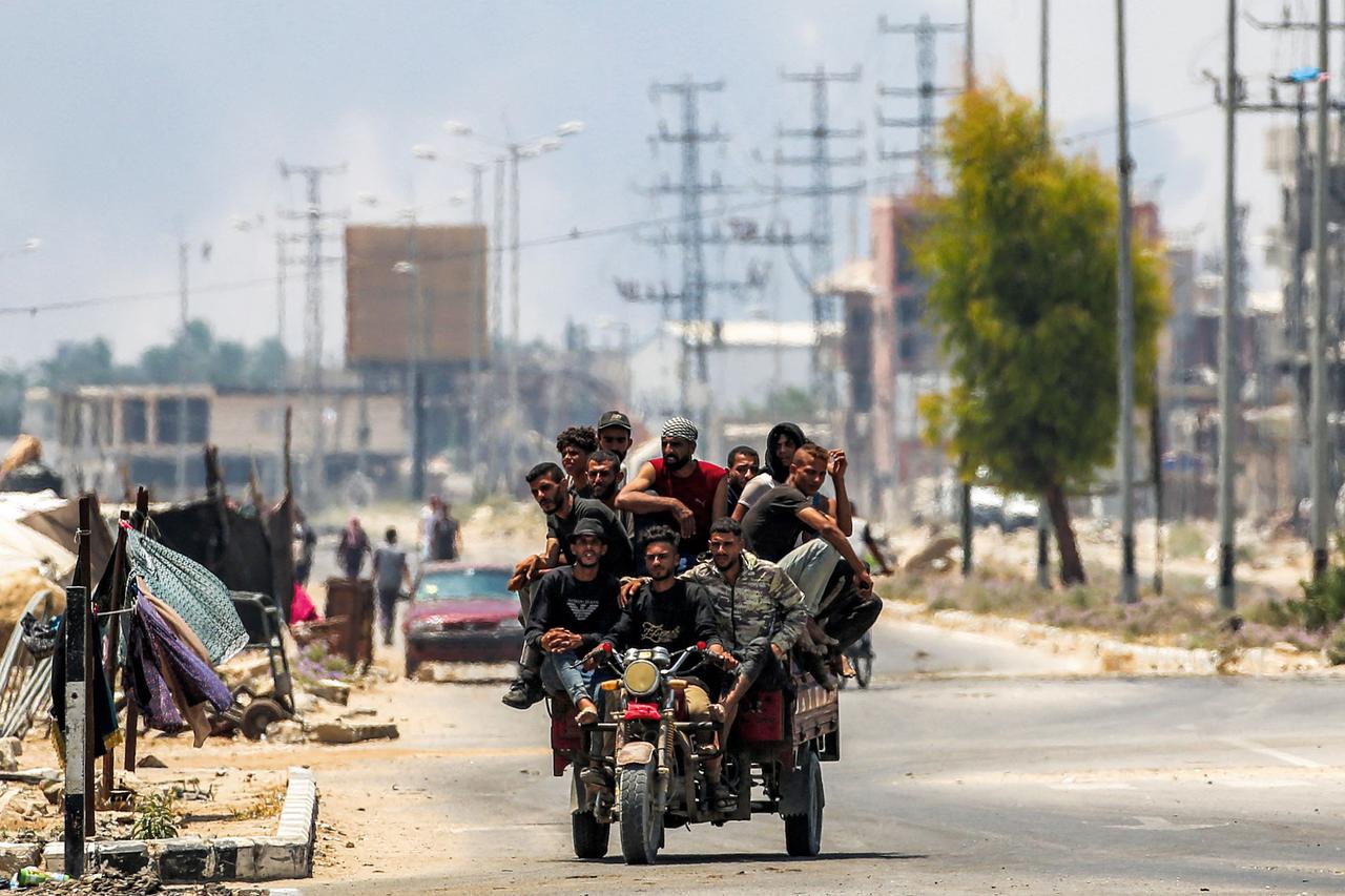 Cette photographie réalisée par Eyad Baba montre des hommes circulant sur un triporteur de fortune, le long de la route principale de Deir Al-Balah, dans le centre de la bande de Gaza, le 21 juillet 2025. 