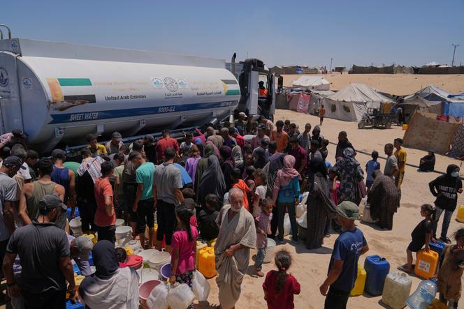 Des Palestiniens déplacés se rassemblent pour recueillir de l’eau d’un camion-citerne dans un camp à Khan Younès, dans le sud de la bande de Gaza, samedi 19 juillet 2025.