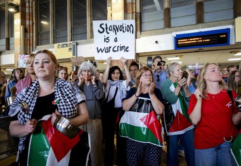 Une femme brandit une pancarte « la famine est un crime de guerre », lors d’un rassemblement à la gare centrale d’Amsterdam (Pays-Bas), le 24 juillet 2025.