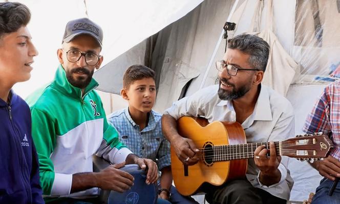 Ahmed Abu Amsha, à la guitare, créateur du groupe Gaza Birds Singing, dans son camp, à Gaza, le 30 mai 2025.